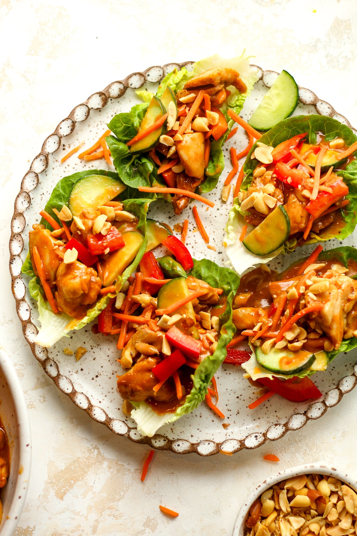 A plate of chicken lettuce wraps with peanut sauce.