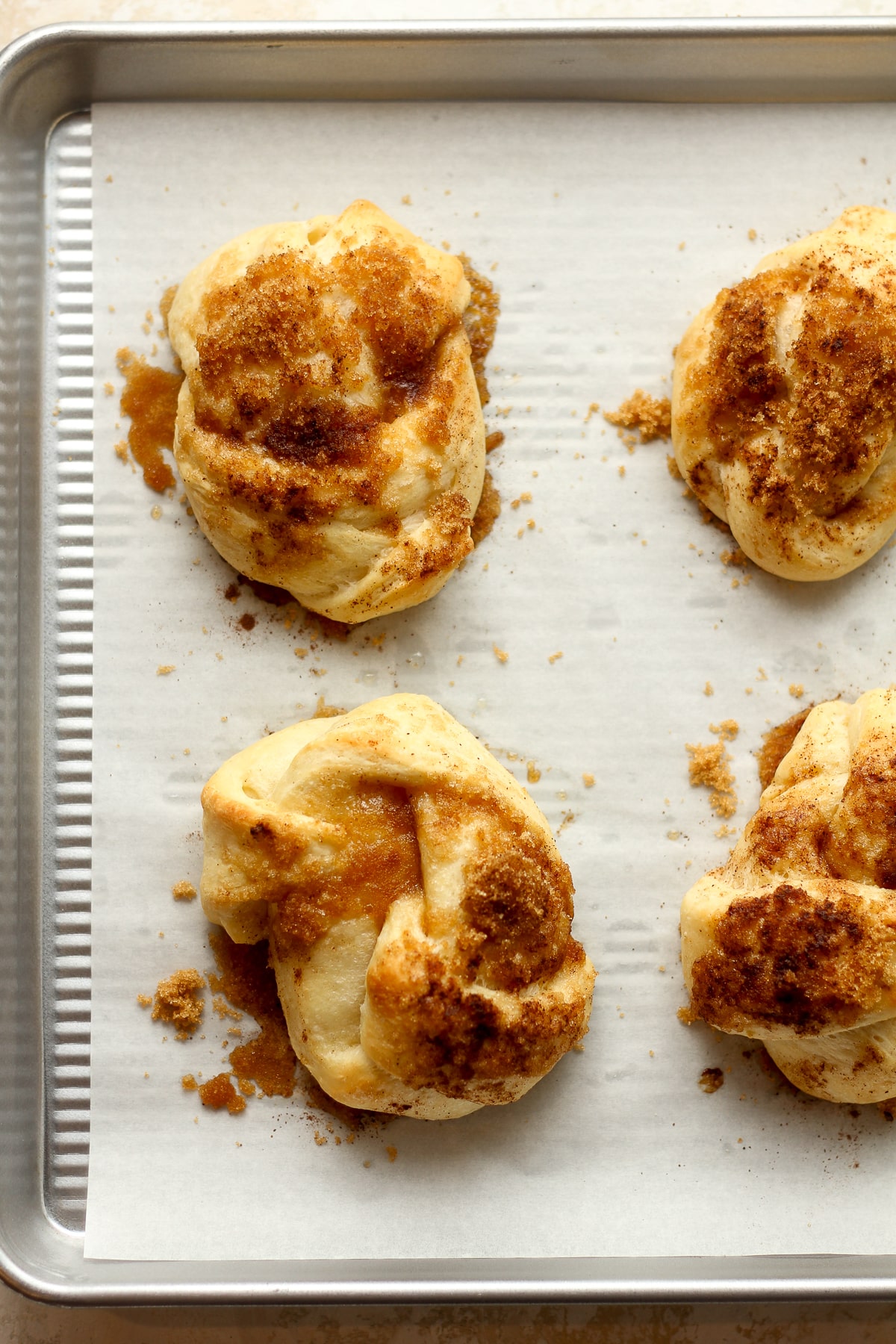 The cinnamon roll knots on a pan after baking.