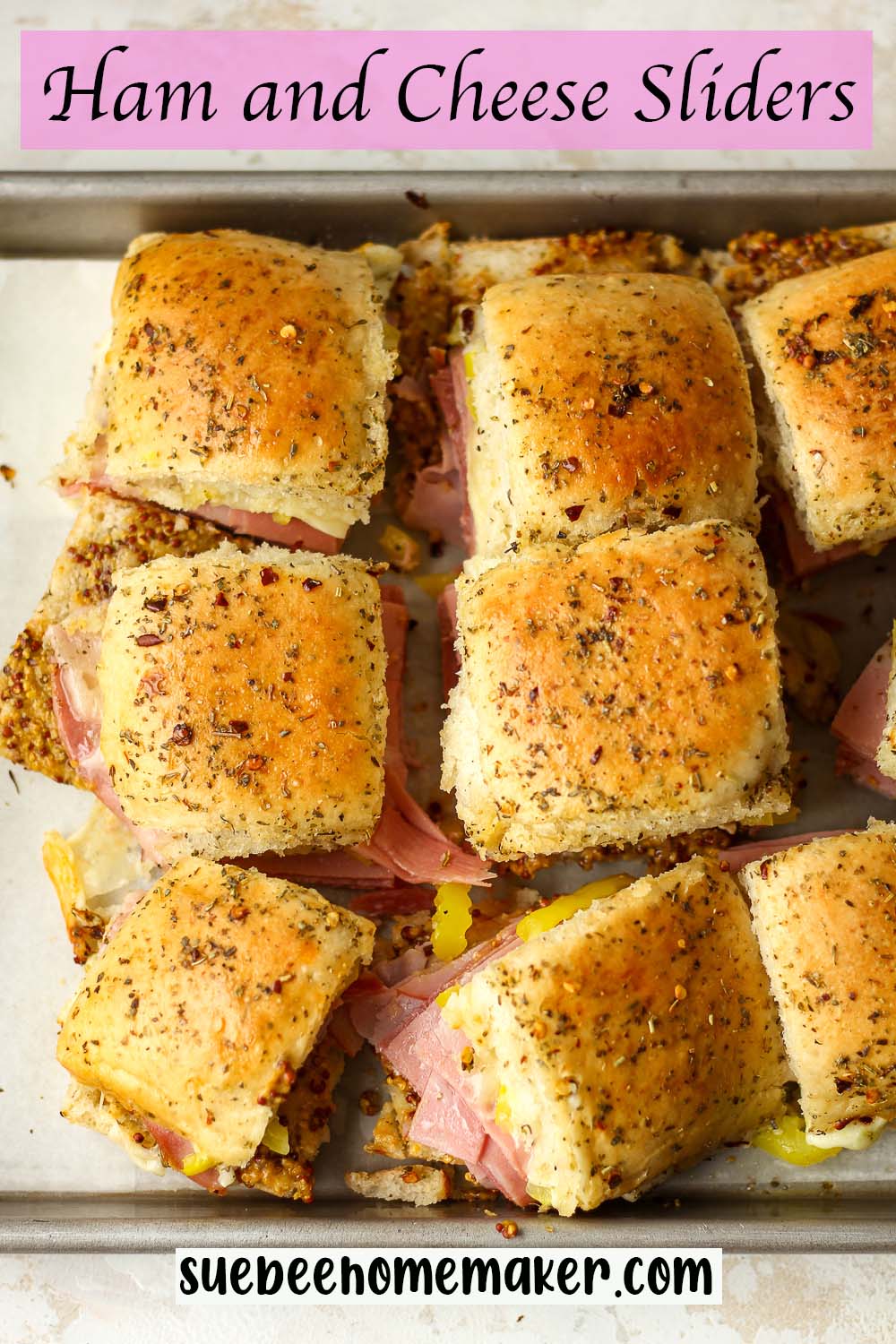Some sliced ham and cheese sliders on a pan.