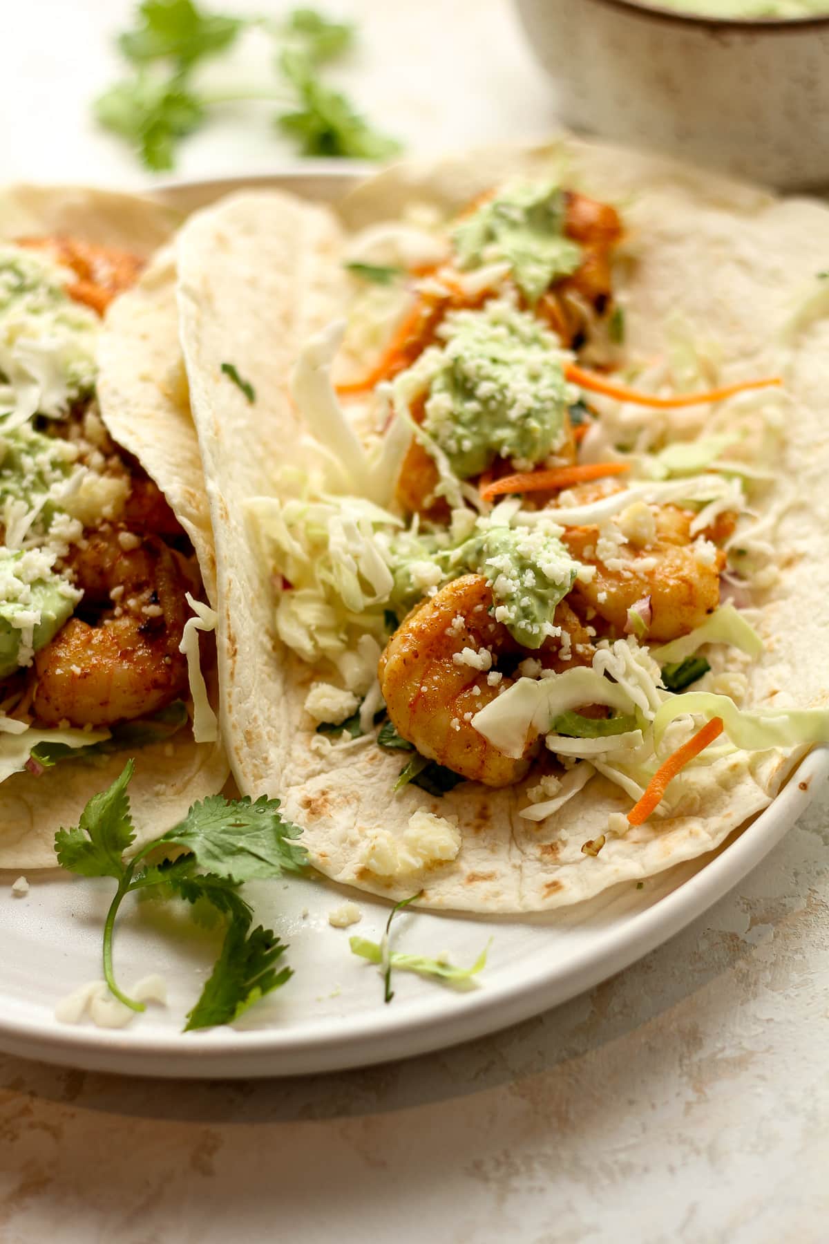 Side view of a shrimp taco with toppings.