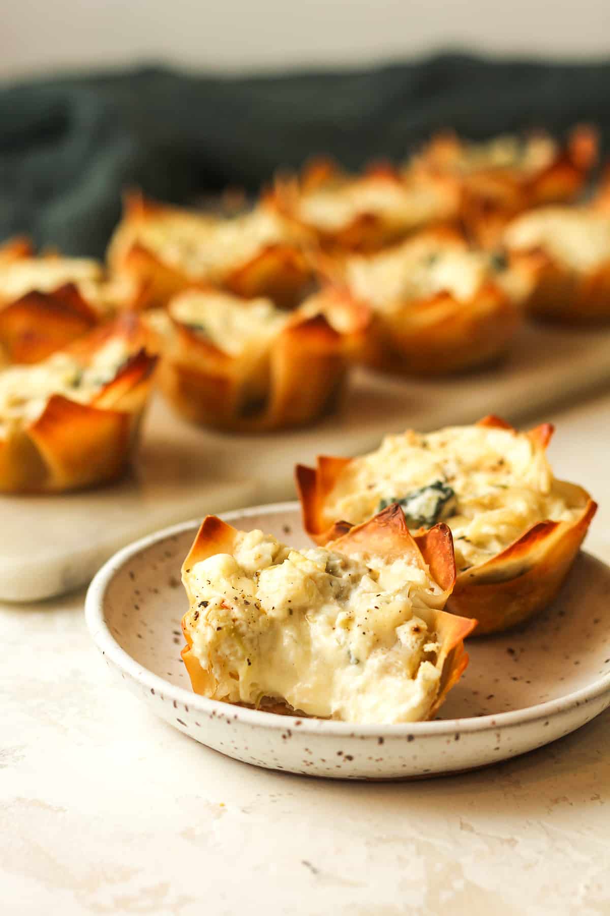 Side view of a small plate of artichoke bites with one missing a bite.