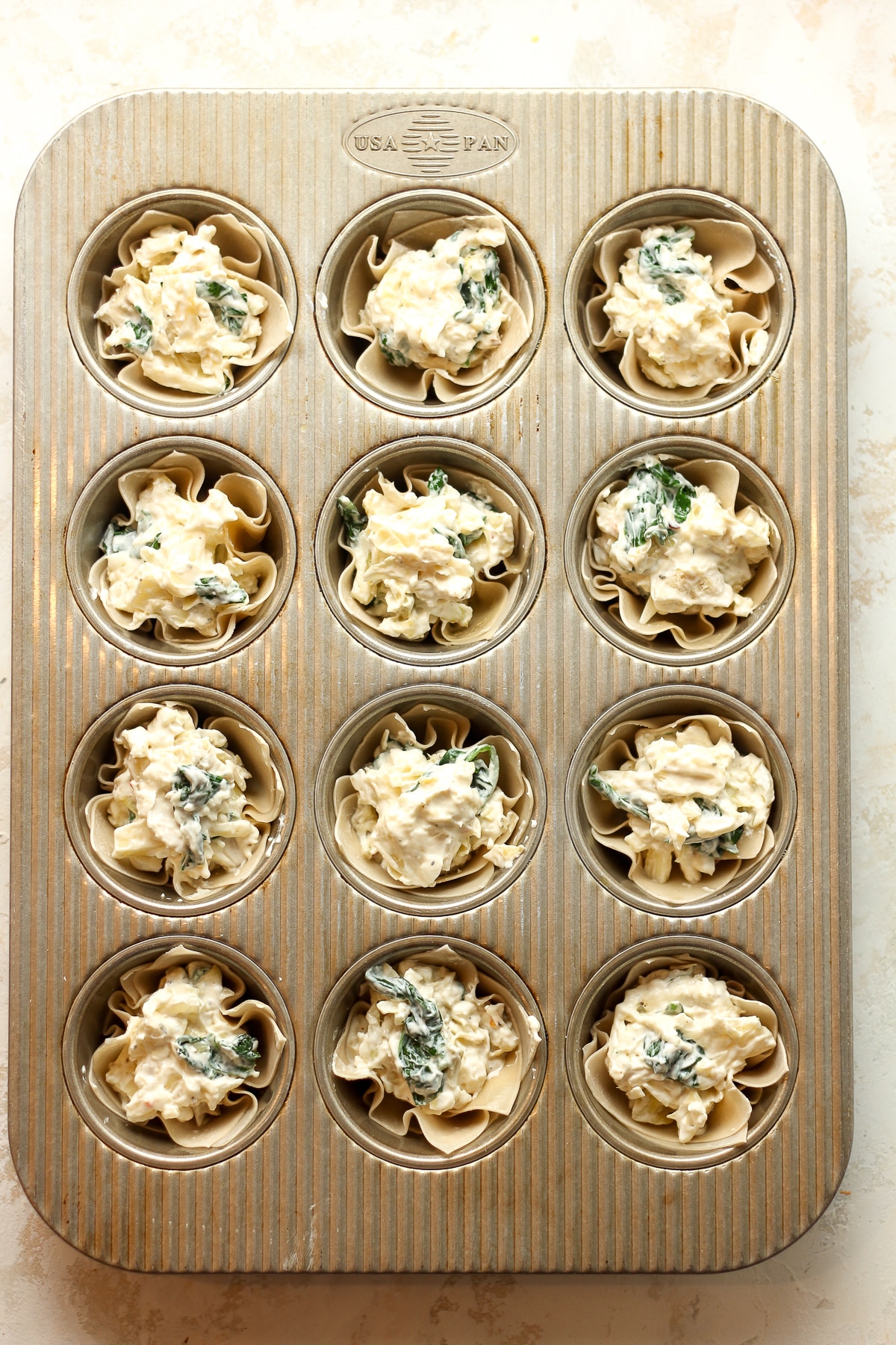 A pan of unbaked artichoke bites.