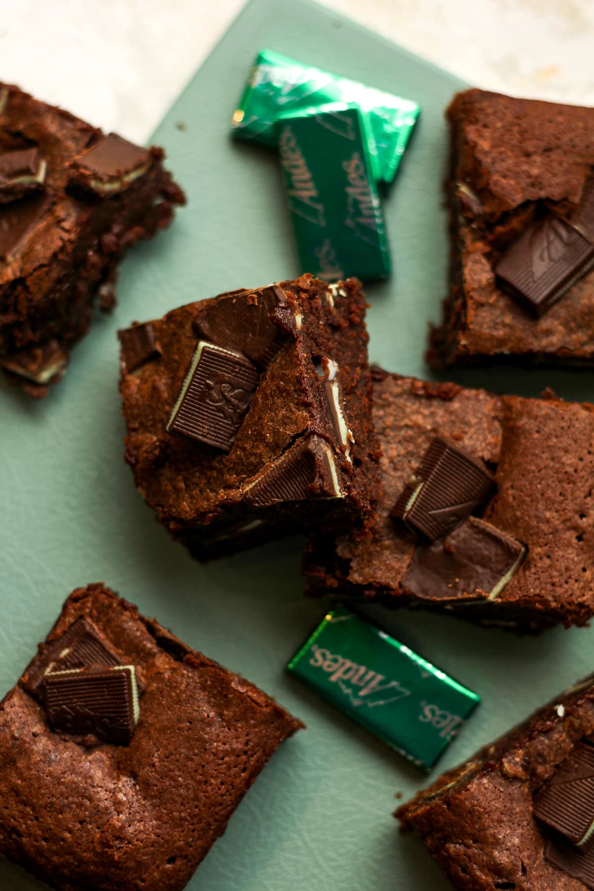 Overhead view of some squares of Andes mint brownies on a green tray.