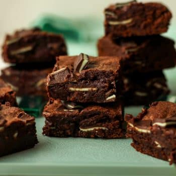 Some stacked Andes mint chocolate brownies on a green tray.