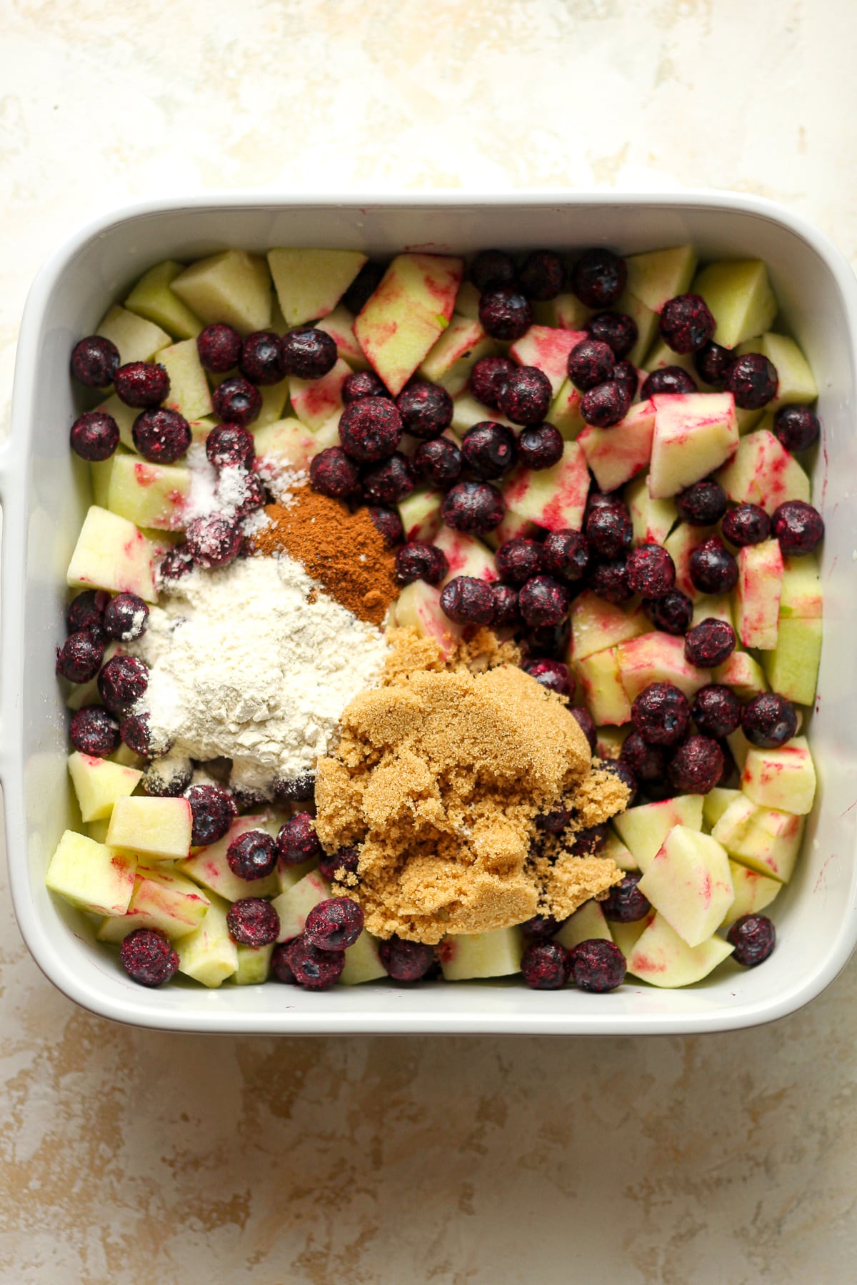 A dish of the fruit layer with sugar, flour, cinnamon, and salt.