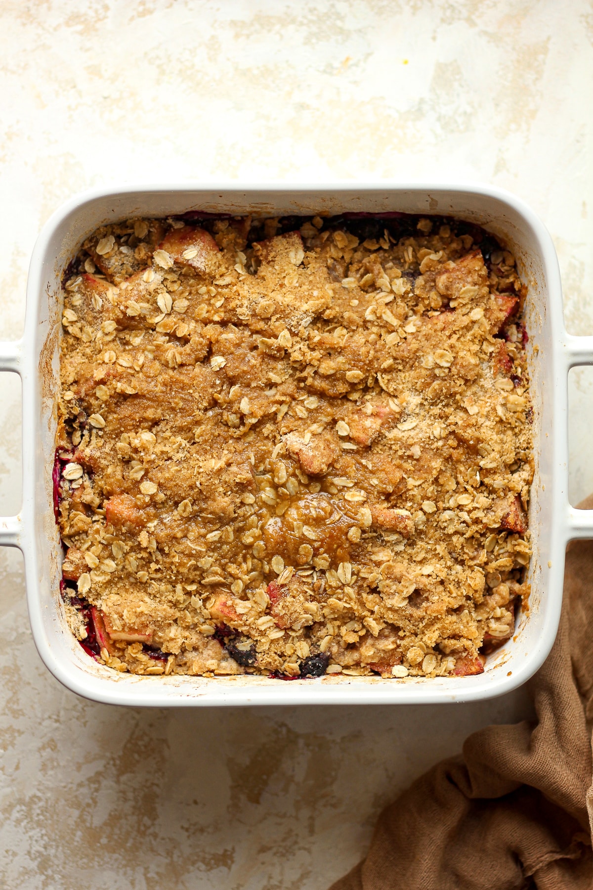 A square dish of the crisp after adding the topping.