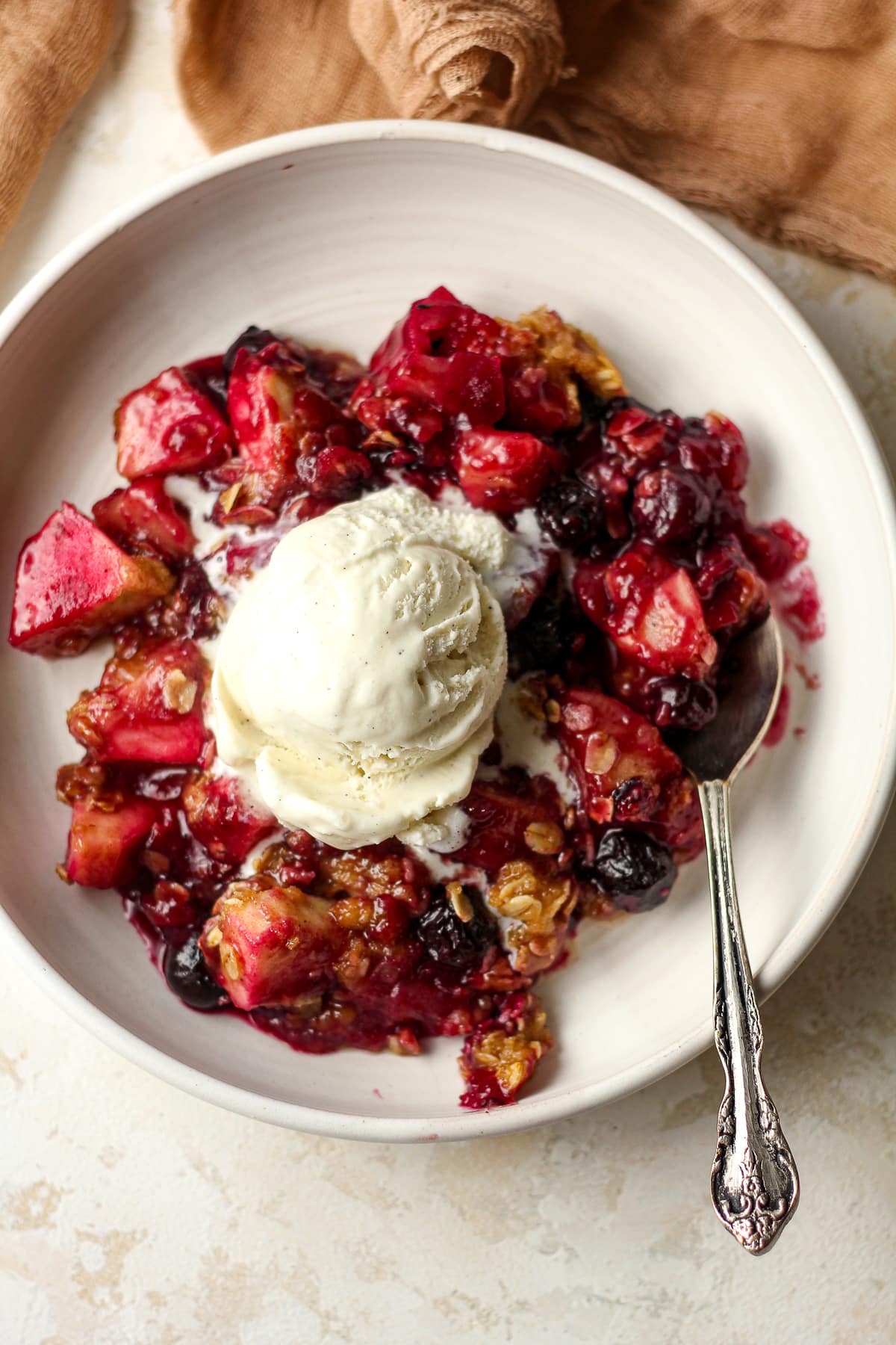 A bow of the crisp with a scoop of vanilla ice cream.