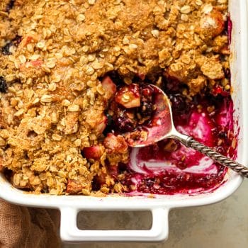 A closeup on a dish of apple blueberry crisp.