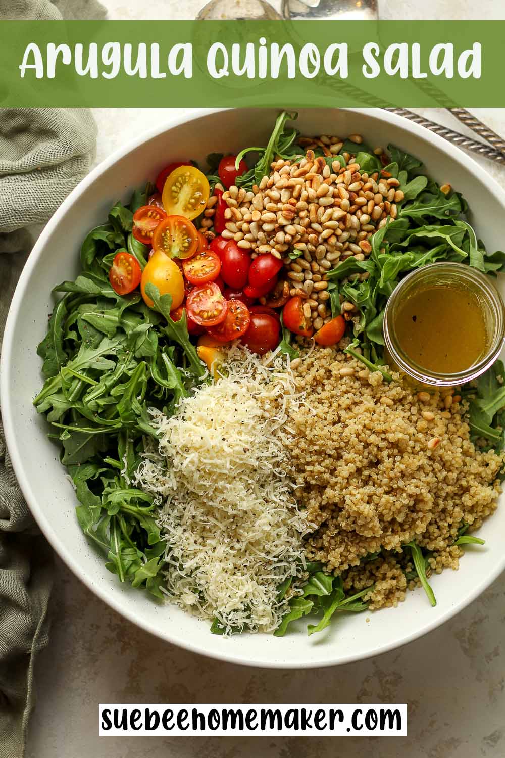 A large bowl of arugula quinoa salad separating by ingredient.