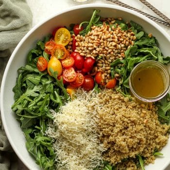 A large bowl with arugula quinoa salad.