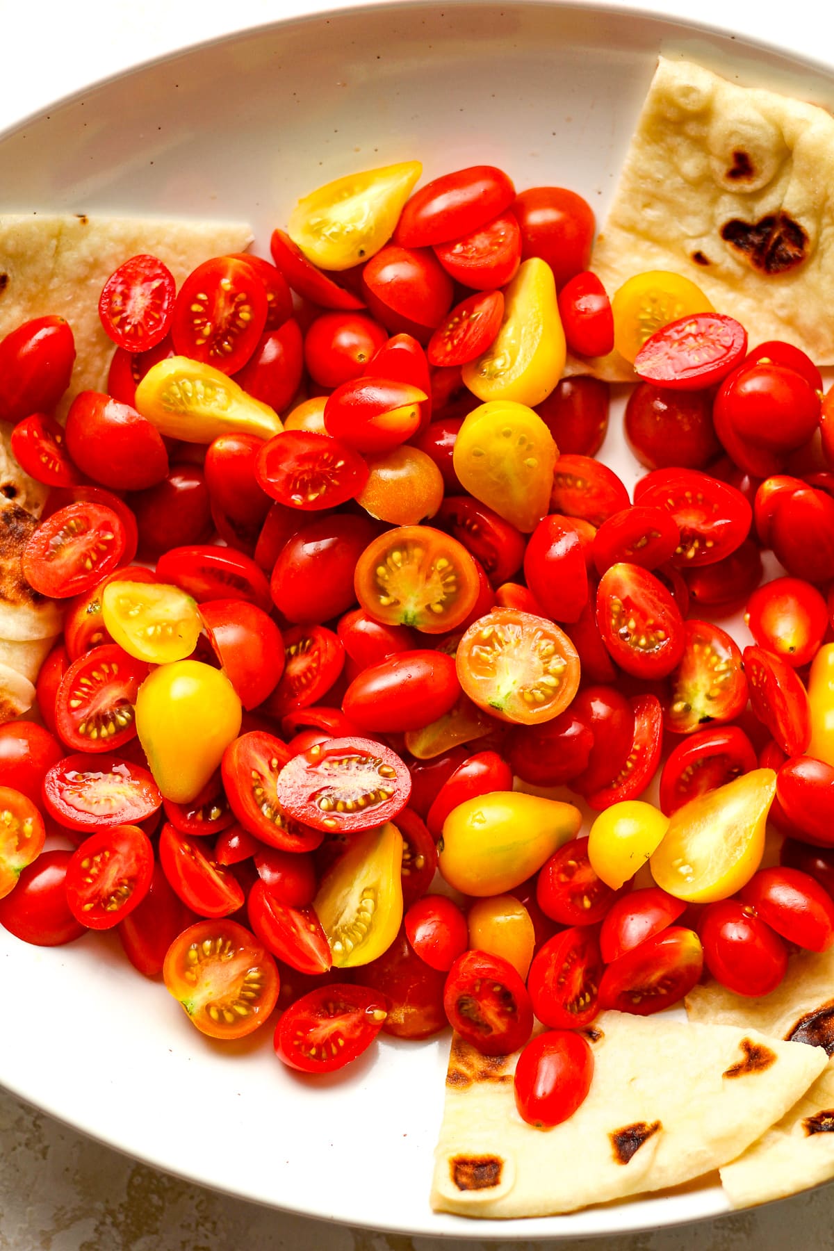 The bowl of halved colorful cherry tomatoes.