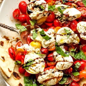 Closeup on burrata caprese salad with balsamic glaze.