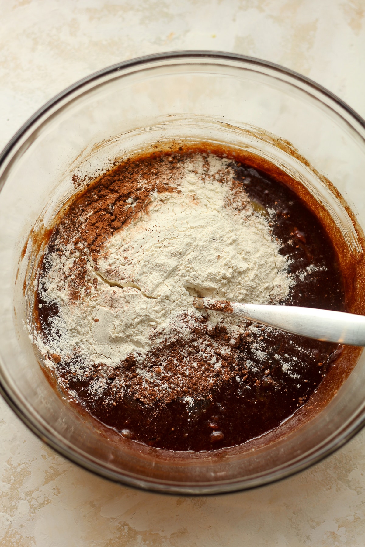 A bowl of the wet batter plus flour and cocoa powder on top.