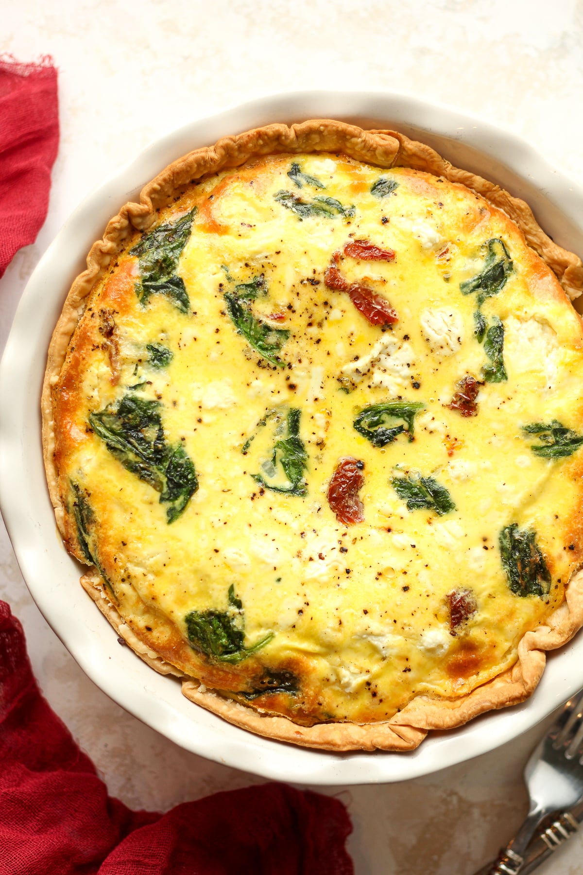 A goat cheese quiche with baby spinach.