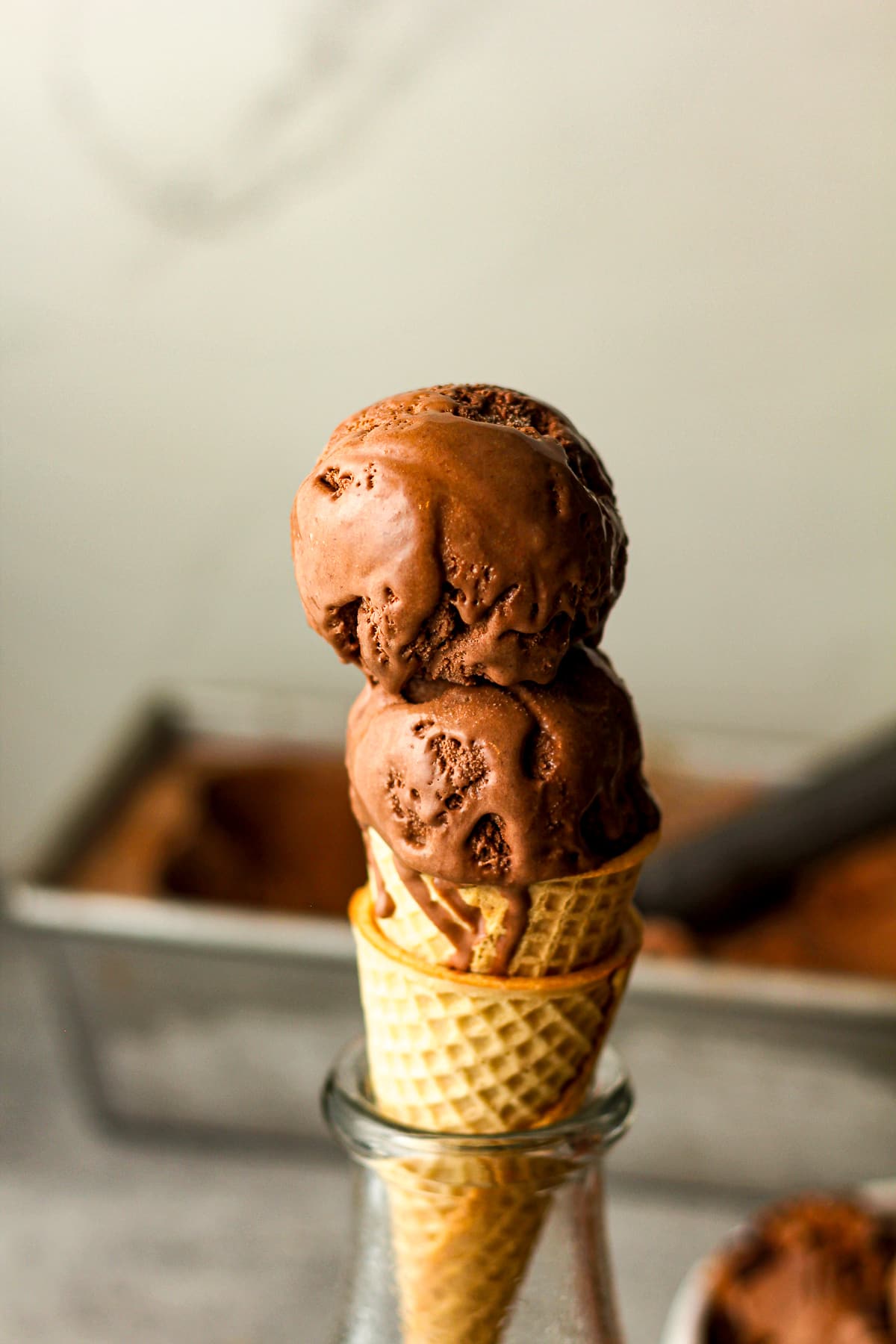 Side view of a drippy chocolate ice cream cone.