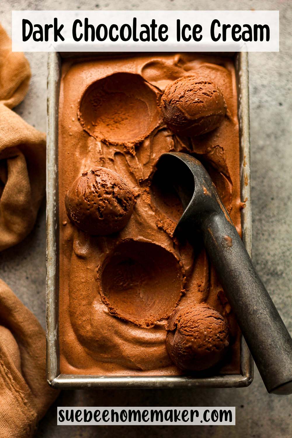 A loaf pan of dipped dark chocolate ice cream with a scoop.