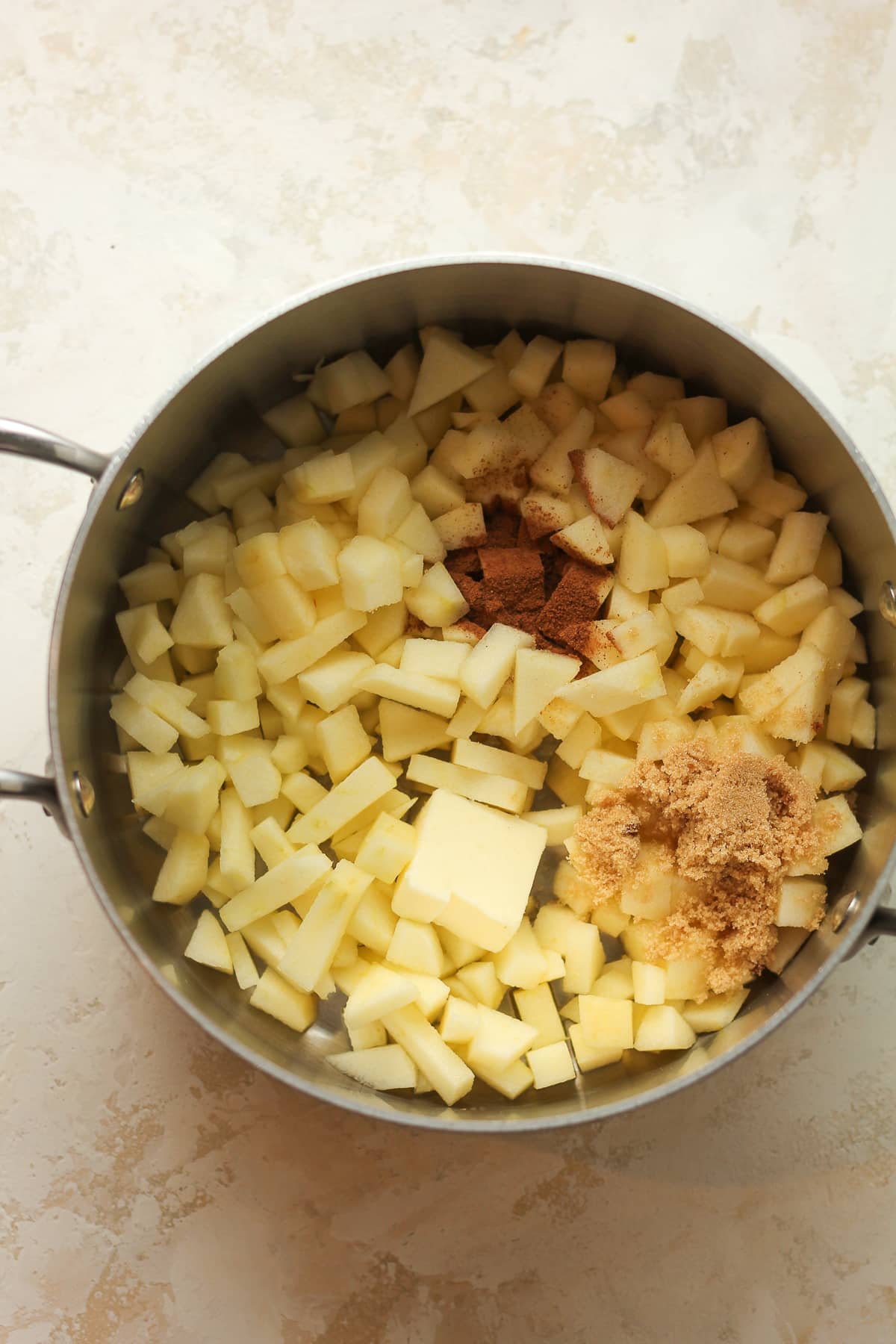 A pan of diced apples, cinnamon, butter, and brown sugar.