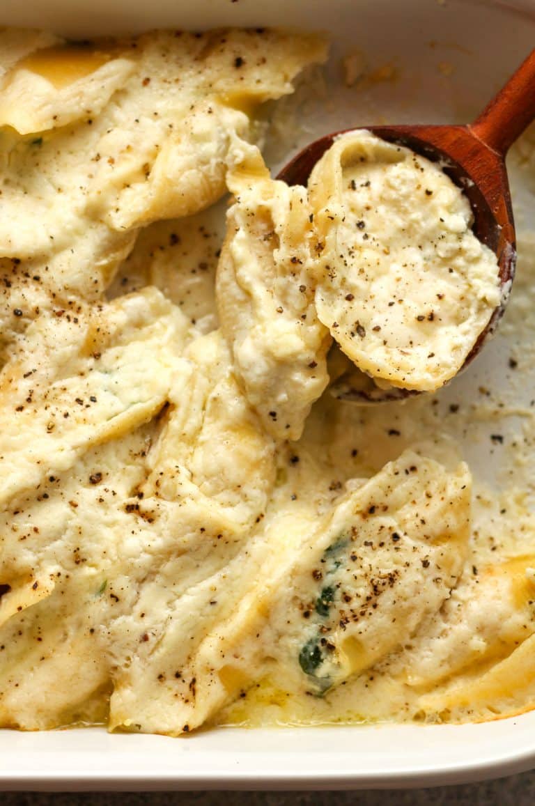 Closeup on some baked shells with Alfredo.