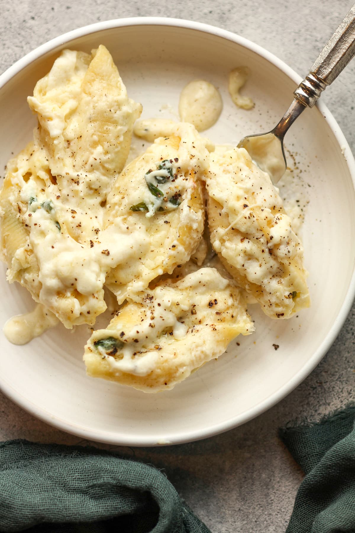 A serving bowl of baked Alfredo shells.