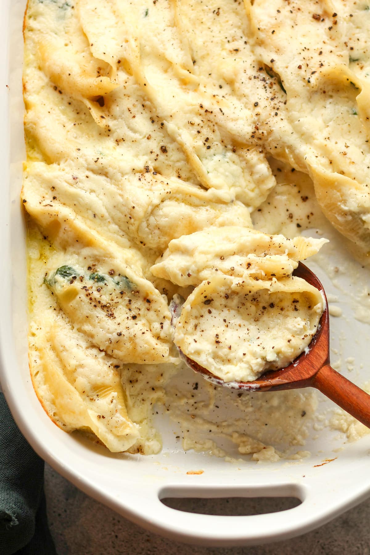 Overhead view of giant stuffed shells with a wooden spoon.