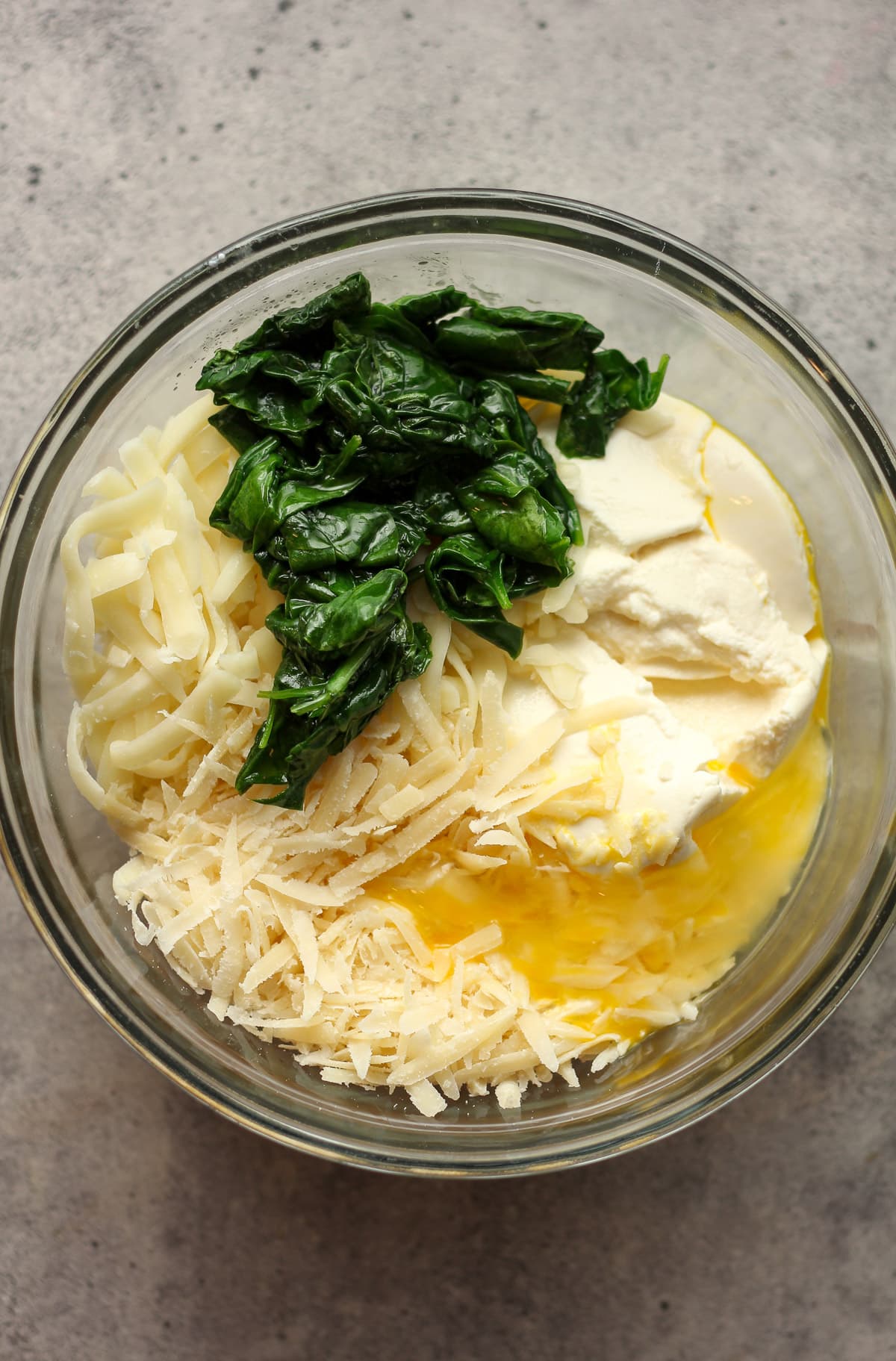 A bowl of the filling for the shells - cheese, egg, and spinach.