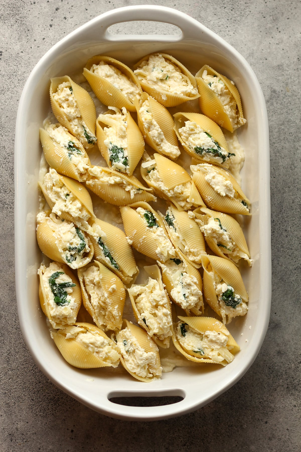 A casserole dish of the unbaked shells before adding sauce.