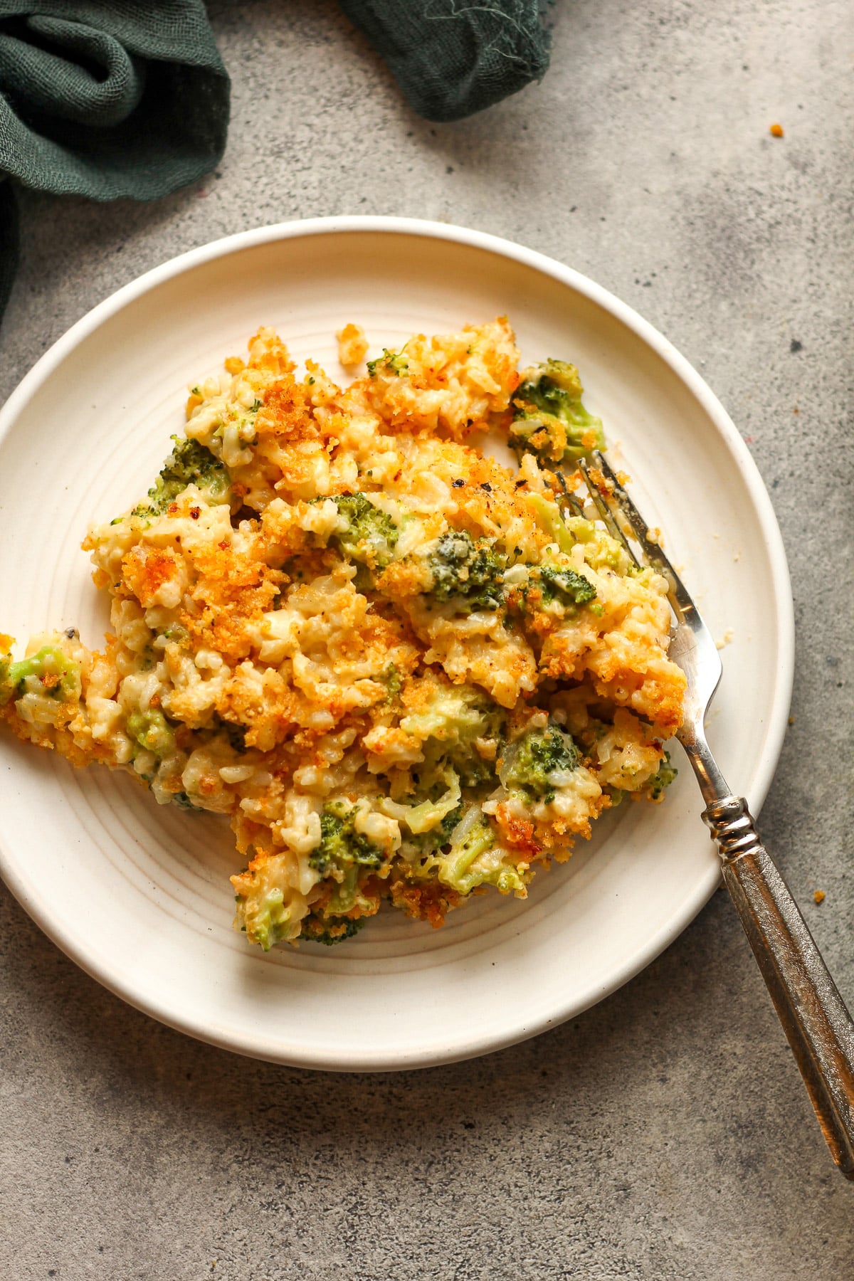 A serving plate of broccoli rice casserole with a fork.