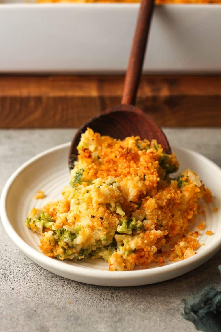 A wooden spoon serving some broccoli rice casserole.