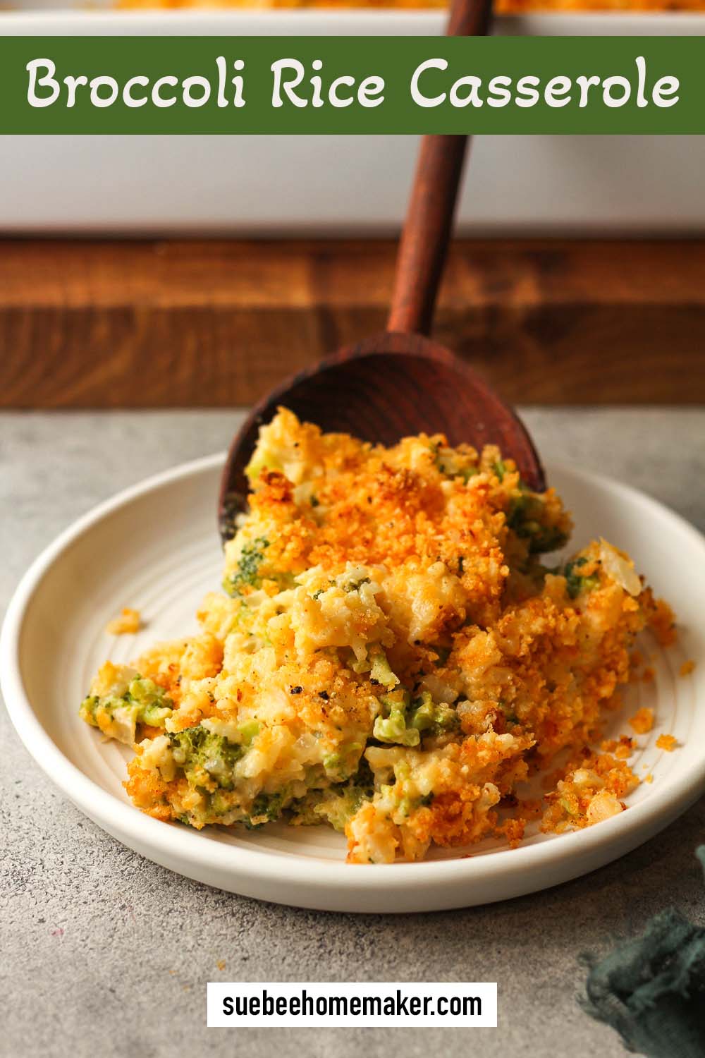 A wooden spoon serving up some broccoli rice casserole on a plate.