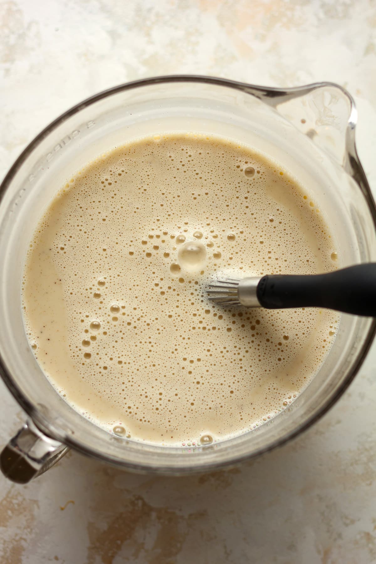 A large measuring cup of the cinnamon ice cream liquid.