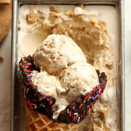 Closeup on a pan of a waffle cone of cinnamon ice cream in a loaf pan of ice cream.