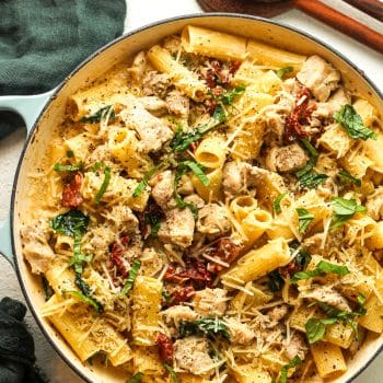 A pot of marry me chicken pasta with fresh basil.