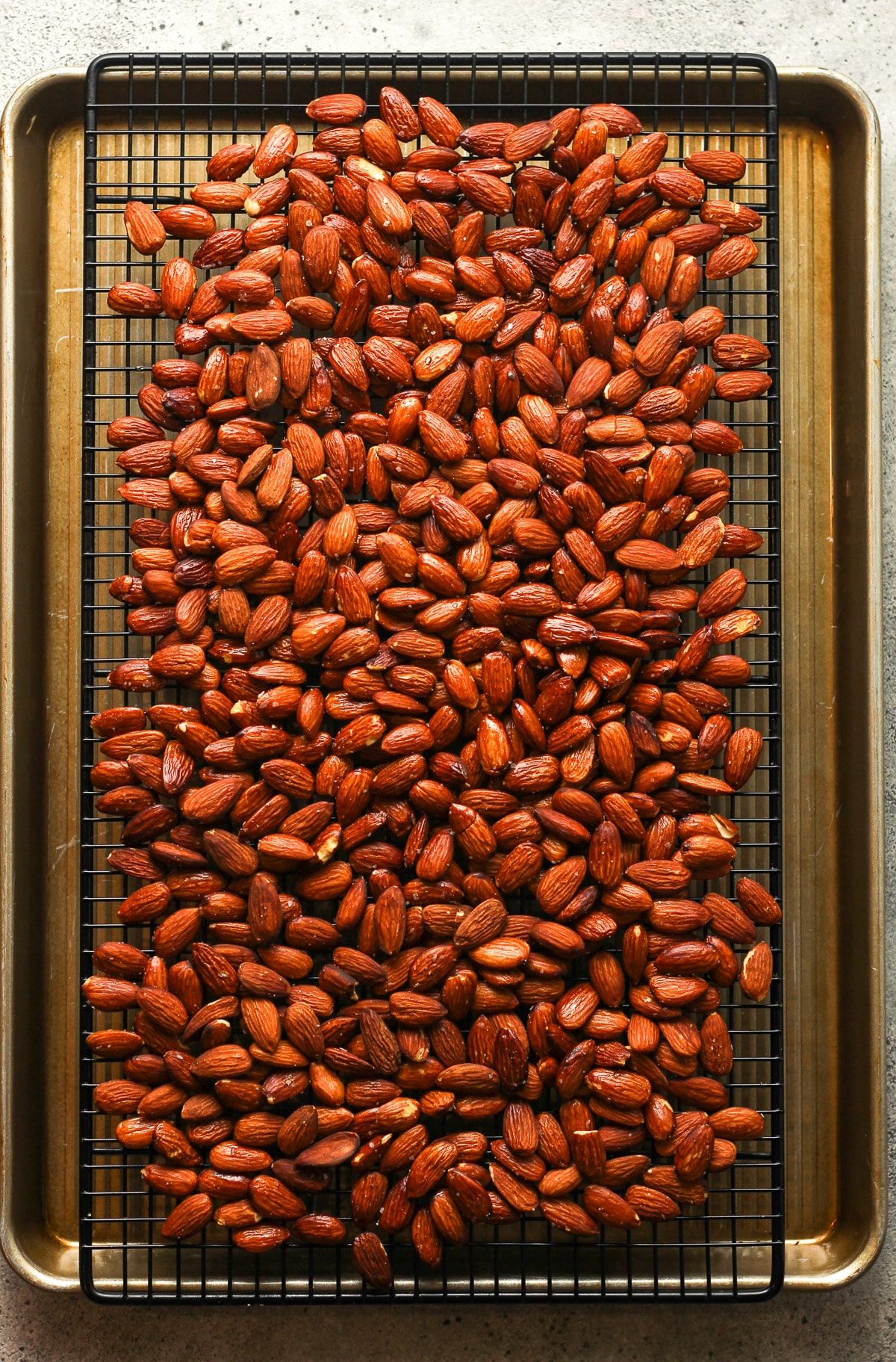 The smoked almonds on a wire rack above a pan to cool.