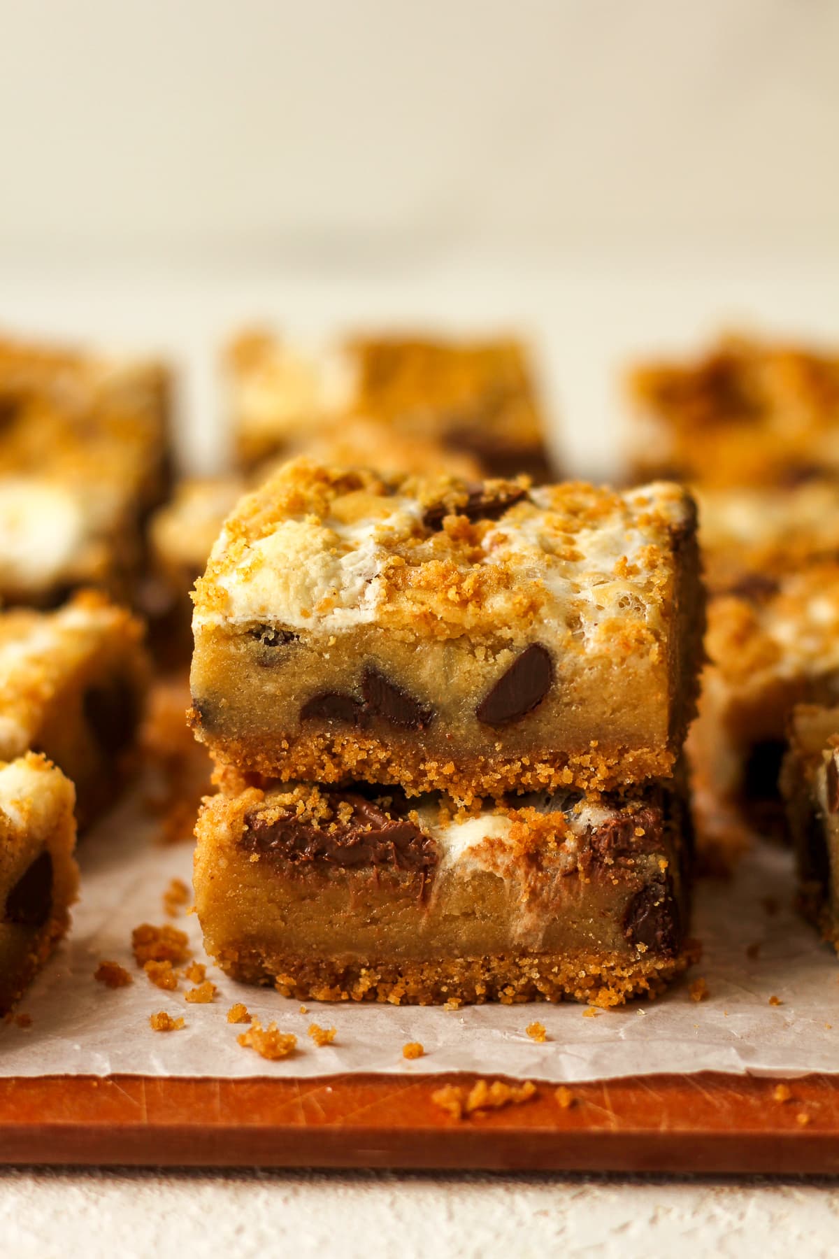 Side view of two stacked s'mores cookie bars on graham cracker crust.