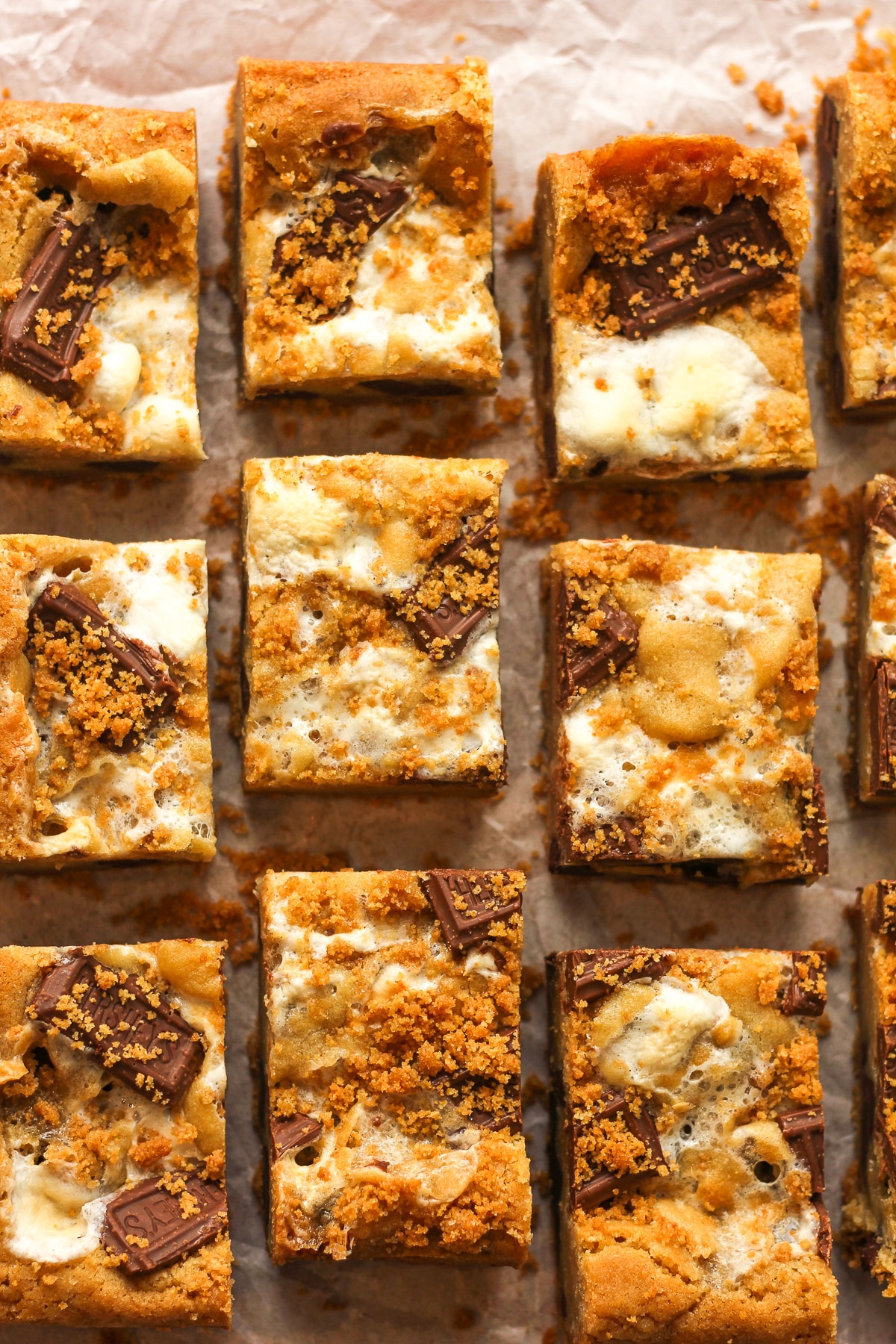 Several slide s'mores bars on white parchment paper.