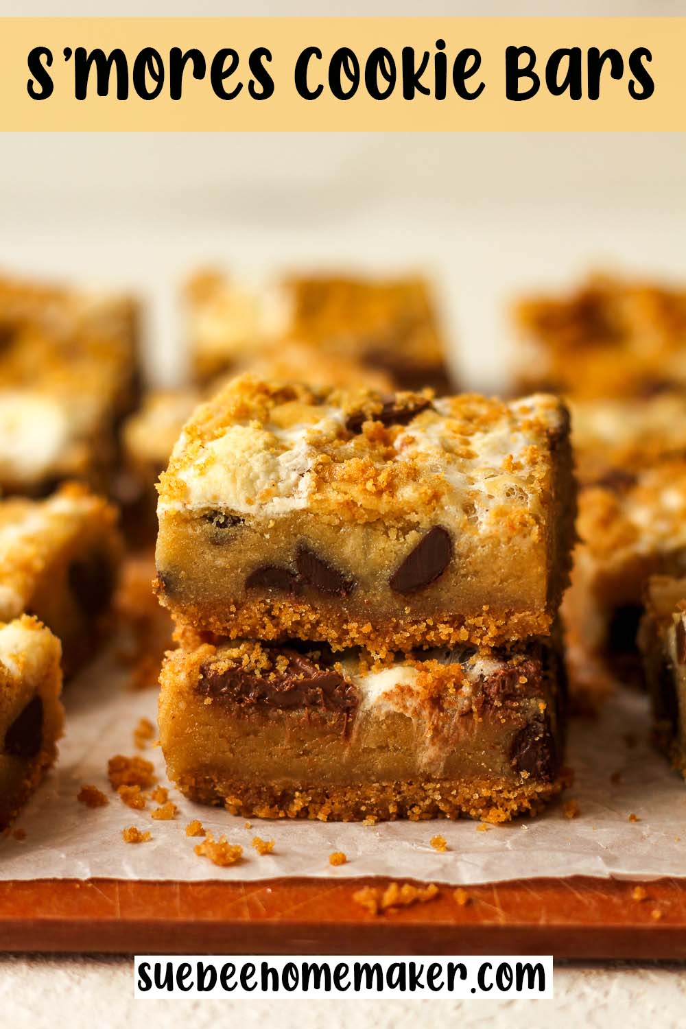 Side view of two stacked S'mores Cookie Bars on white parchment paper.