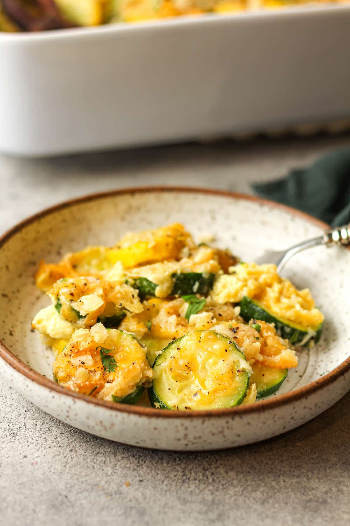 Side view of a serving of squash casserole with a fork.