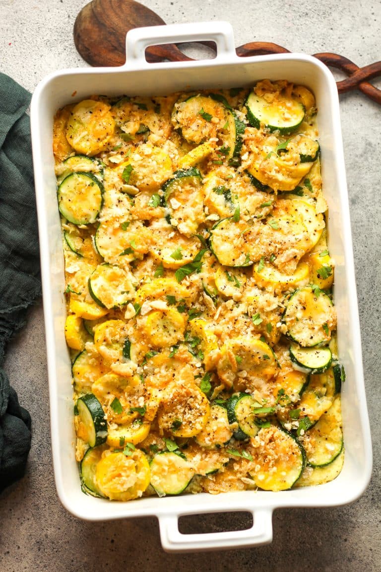 The baked squash casserole with a wooden spoon.