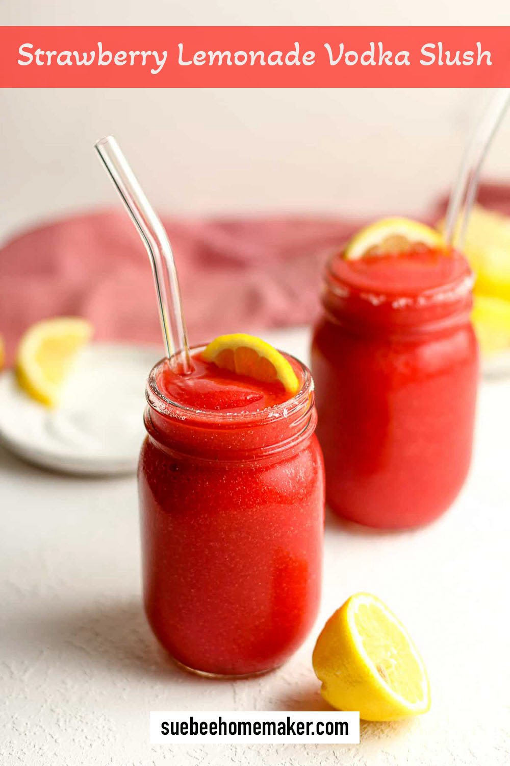 Side view of two mason jars full of strawberry lemonade vodka slush.