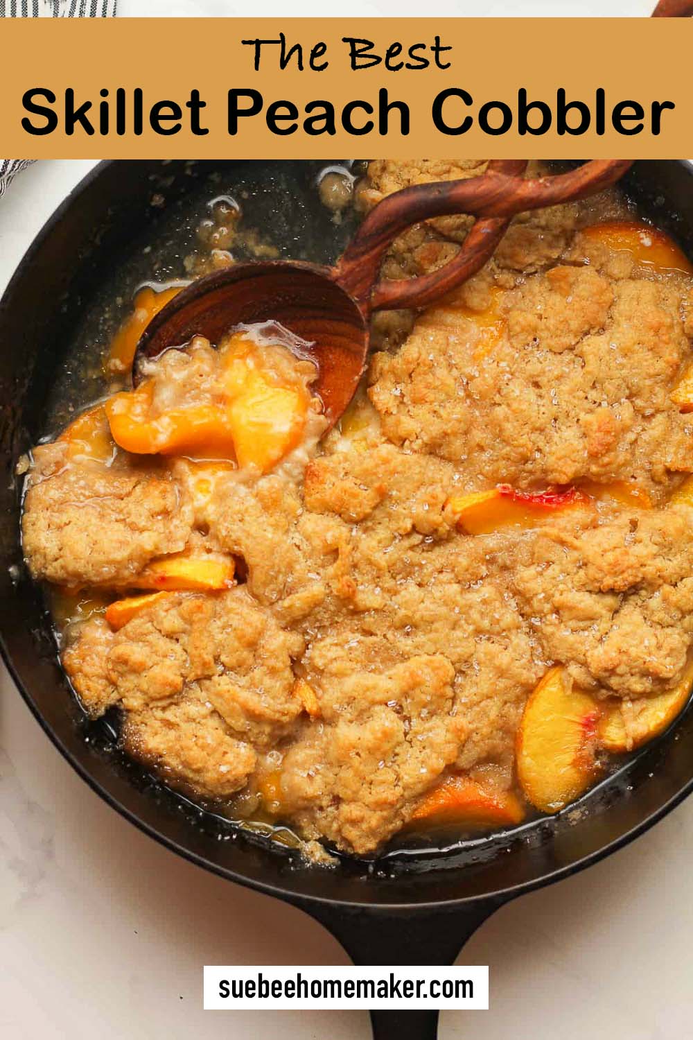 Closeup on the Best Skillet Peach Cobbler with a wooden spoon.