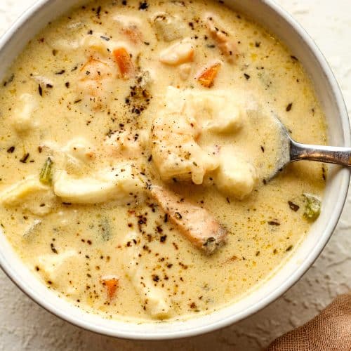 Closeup on a bowl of the seafood chowder with a spoon.