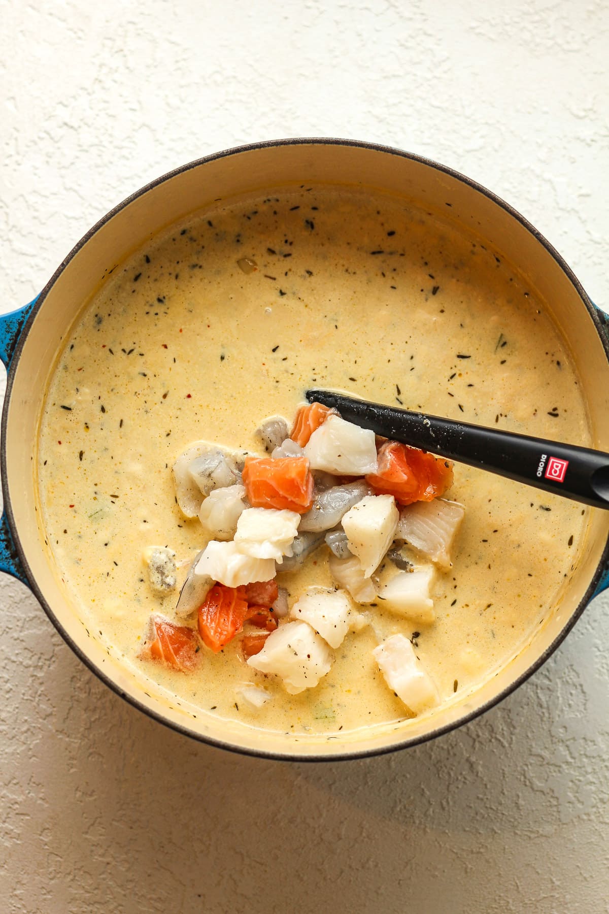 A pot of the chowder after adding seafood.