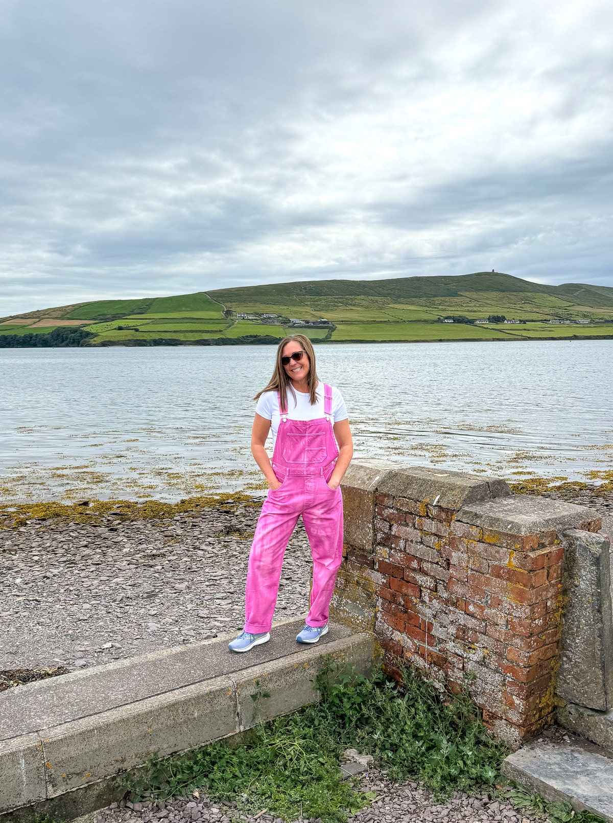 Sue posing in pink overalls outside of the Dingle hotel.