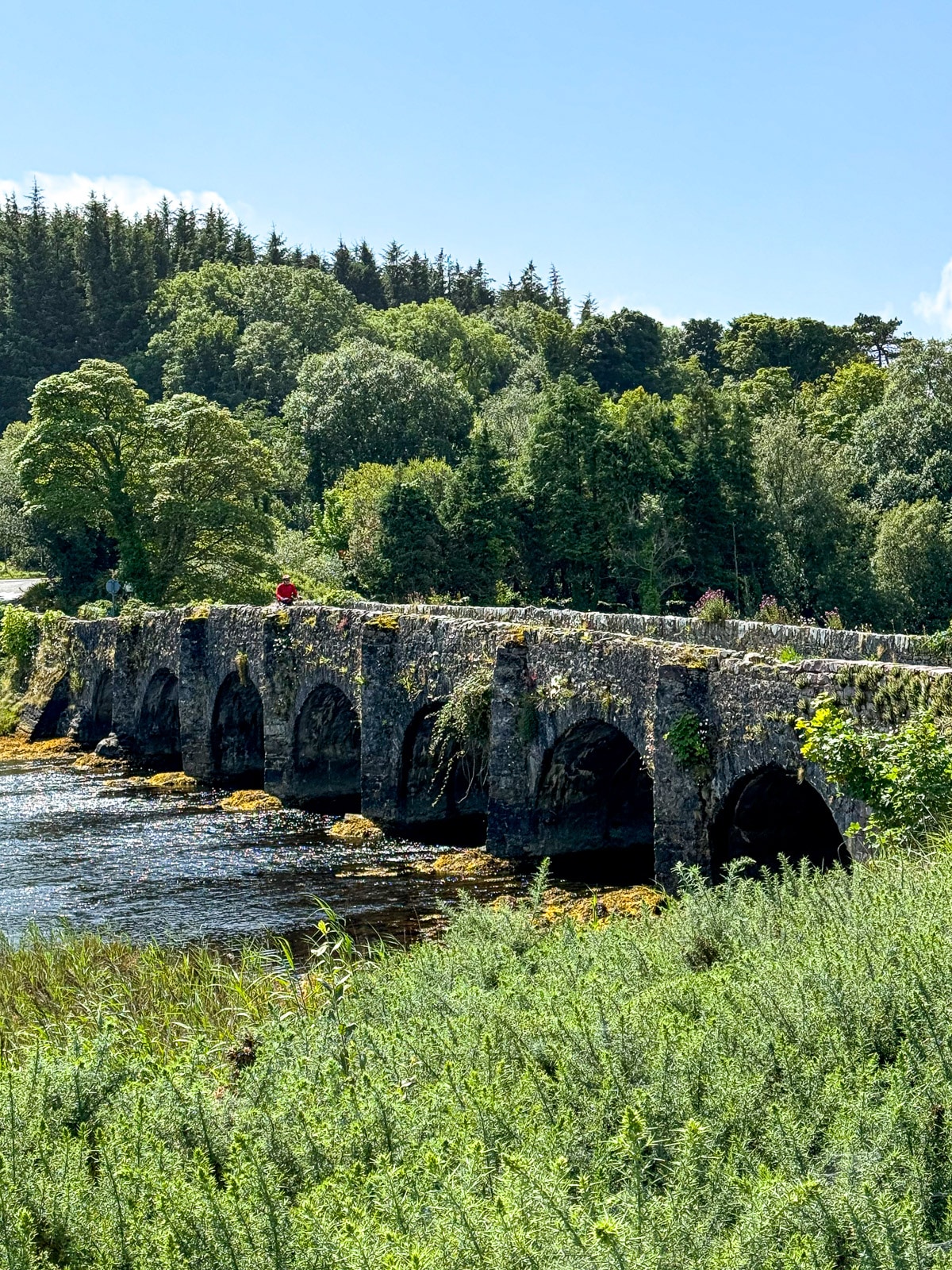 A view of the beautiful stone bridge and Mike biking across it.