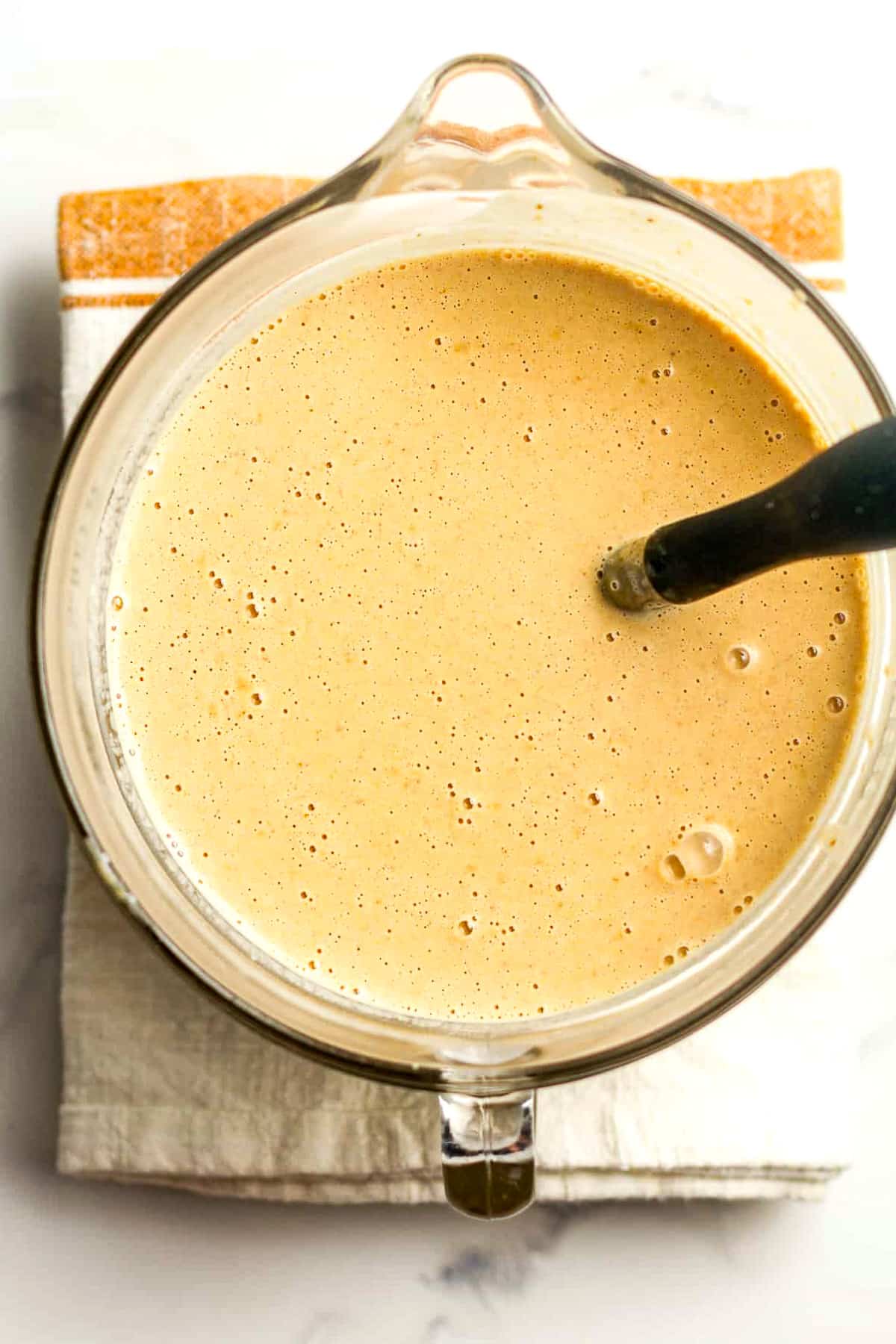 A large measuring cup of the liquid pumpkin ice cream.