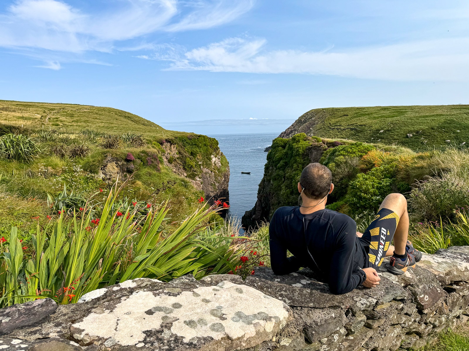 Mike lying on a rock ledge looking at the coast.