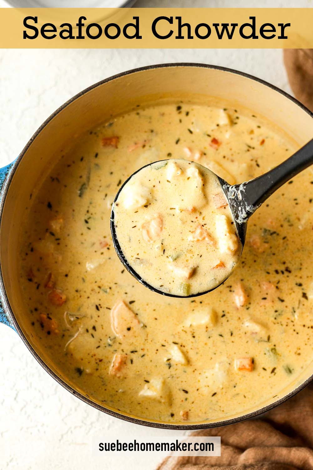 Overhead view of a pot of seafood chowder with a ladle.