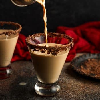 A stream of chocolate martini being poured into a glass.