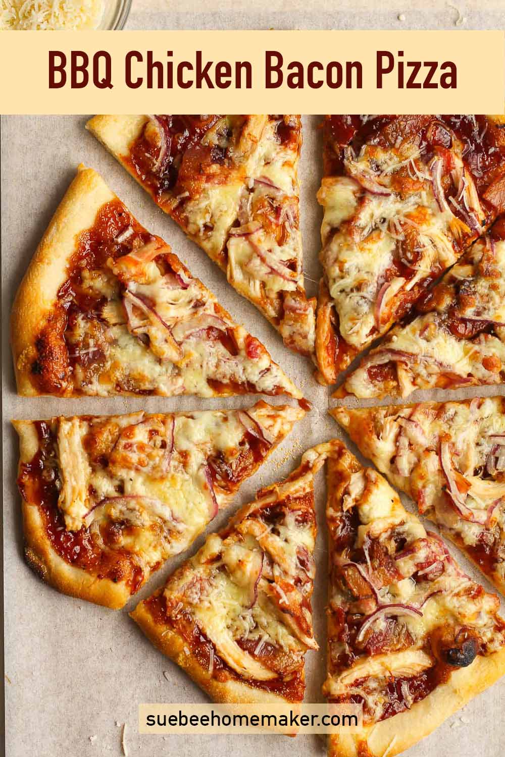 A sliced BBQ chicken bacon pizza on white parchment paper.