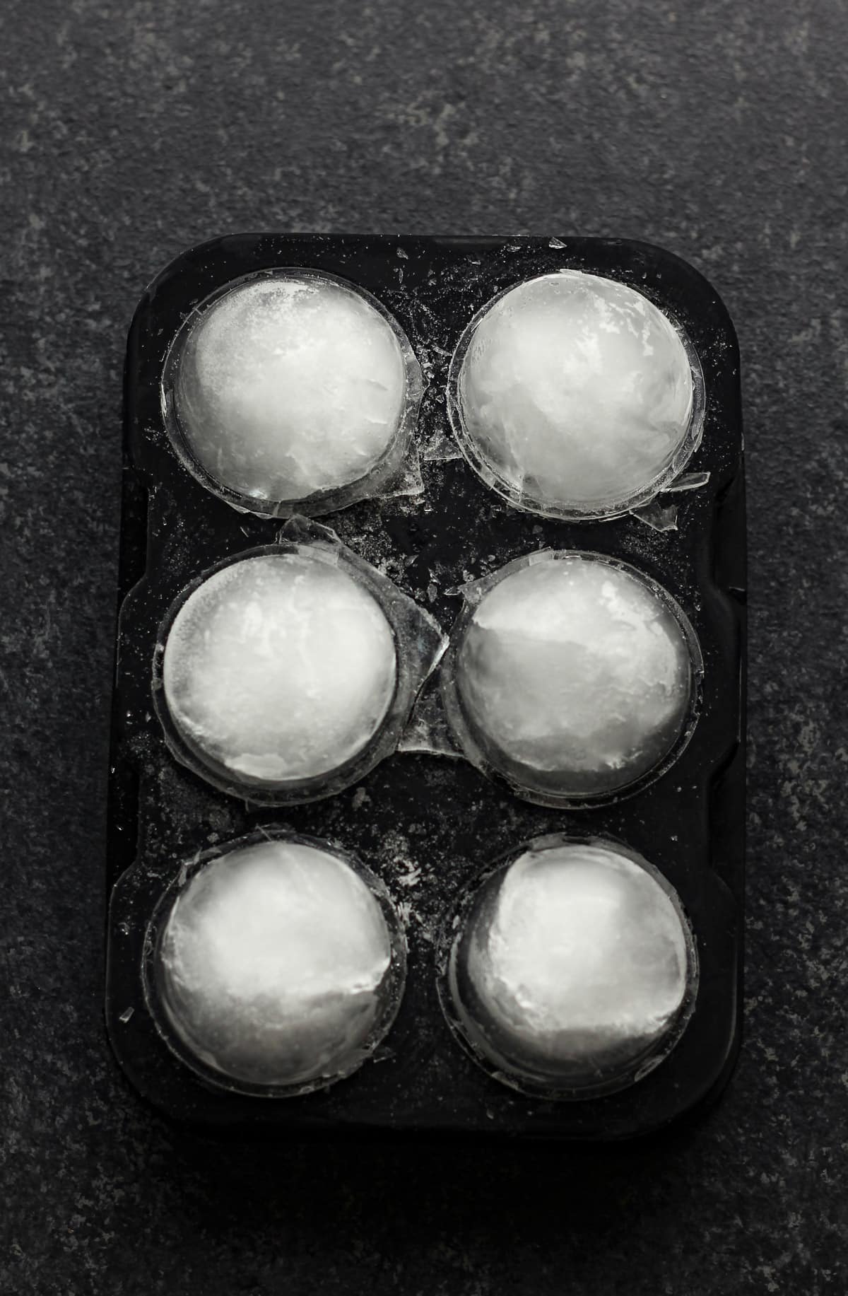 An ice cube tray with six round cubes.